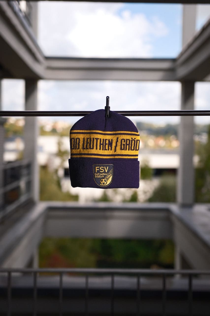 Sportliches Mikrofaser-Handtuch mit farbigem Vereinswappen, schnell trocknend und leicht.